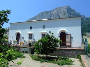 a white house with a mountain in the background at Lilli's House in Capri in Capri