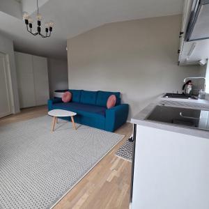 a living room with a blue couch and a table at Tiny Home in a Tiny Town in Hjärup +4 photos
