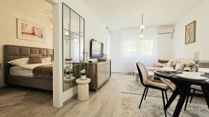 a bedroom with a bed and a dining room at Royal Apartman in Banja Koviljača