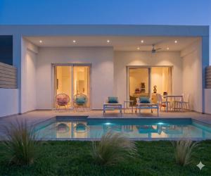 a house with a swimming pool in the yard at Splash Suites with Private Pools in Nikiana