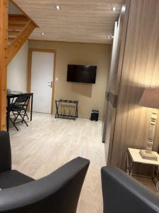 a living room with a table and a television on the wall at Le 8 du Pontois in Ciney