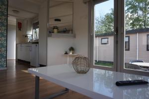 a kitchen with a white table and a window at 't Veldhuisje 109 - naast het bos, honden toegestaan in Anloo