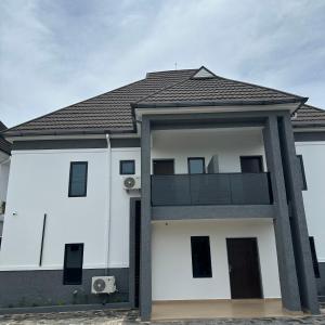a white house with a black roof at Greyfield Apartment Anex in Benin City