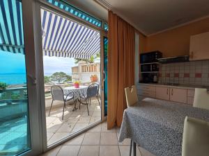 a kitchen with a table and a balcony with a view of the ocean at VILLA Bose in Brela