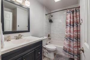 a bathroom with a sink and a toilet and a mirror at Charming Luxe Home Sleeps 4 in Anchorage