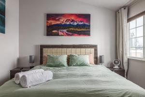 a bedroom with a bed with a painting on the wall at Charming Luxe Home Sleeps 4 in Anchorage