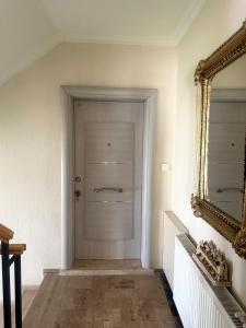 a hallway with a white door and a mirror at Maison Edina - Cunda in Ayvalık