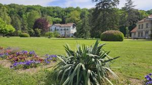 a green field with houses and flowers in a yard at Royal Apartman in Banja Koviljača