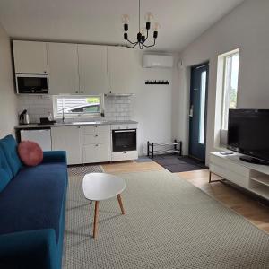 a living room with a blue couch and a kitchen at Tiny Home in a Tiny Town in Hjärup