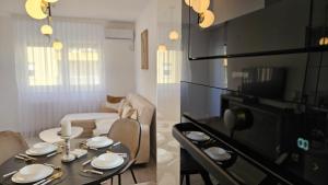 a kitchen and a living room with a table and chairs at Royal Apartman in Banja Koviljača