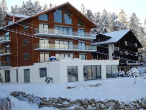 una grande casa nella neve con gli alberi di The Onya Resort & Spa a Bellwald