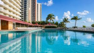 a swimming pool in front of a tall building at Ocean View Apartment In Sunny Isles in Sunny Isles Beach