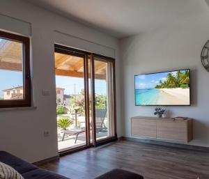 a living room with a flat screen tv on a wall at Luxury Histria Apartment with Private Pool Near the Beach in Banjole