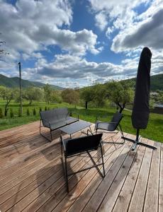 two chairs and a table on a wooden deck at B-House in Tyudov