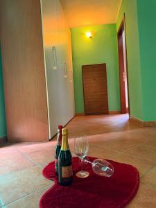 two bottles of wine and a glass on a rug at Casa Lory in Posta Fibreno