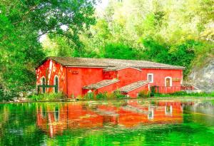 a painting of a red house next to a lake at Casa Lory in Posta Fibreno