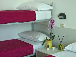 a bedroom with two bunk beds and a vase with flowers at Hotel Ornella in Bellaria-Igea Marina