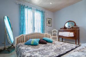 a bedroom with a bed with pillows and a desk at Gîte au Couchant à Caylus - Piscine - Jardin - 3 chambres - 8 personnes - 5 minutes du village médiéval in Caylus +63 photos