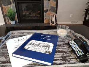 a book and a remote control on a coffee table at Lake Melissa Cabin on the Commons in Detroit Lakes +23 photos