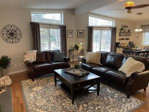 a living room with leather couches and a coffee table at Lake Melissa Cabin on the Commons in Detroit Lakes