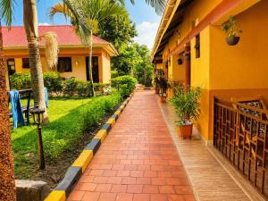 a brick path in front of a house with palm trees at Palm Star Motel in Fort Portal