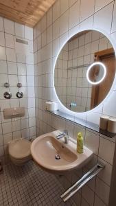 a bathroom with a sink and a toilet and a mirror at Stadthaus Sonneneck in Bad Tölz +21 photos