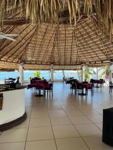 a restaurant with tables and chairs and a large ceiling at PlayaSol las Hadas in Manzanillo