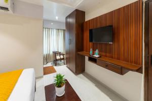 a hotel room with a television on a wall at Lumina Stays-Modern Luxury Rooms, Near NAD in Visakhapatnam