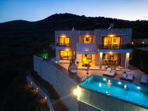 a house with a swimming pool in front of it at Paleokastro Villas with Private Heated Pool, Top Views - Next To Center - Top WiFi in Kissamos