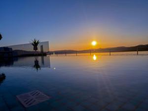 an empty pool with the sunset in the background at Paleokastro Villas with Private Heated Pool, Top Views - Next To Center - Top WiFi in Kissamos