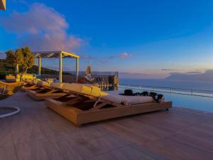a bed on a deck with a view of the water at Paleokastro Villas with Private Heated Pool, Top Views - Next To Center - Top WiFi in Kissamos +90 photos