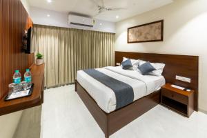 a hotel room with a bed and a desk at Lumina Stays-Modern Luxury Rooms, Near NAD in Visakhapatnam