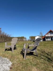 two chairs sitting in the grass in a field at Przystanek Dobra in Dobra +8 photos