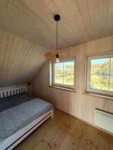 a bedroom with a bed and two windows at Przystanek Dobra in Dobra