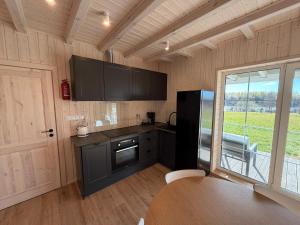 a kitchen with a black refrigerator and a table at Przystanek Dobra in Dobra