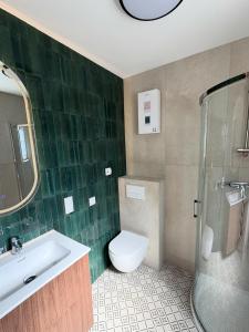 a bathroom with a toilet and a sink and a shower at Przystanek Dobra in Dobra