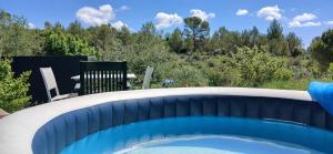 a swimming pool in a backyard with a table and chairs at Studio clim 4-5 pers animaux, mai oct spa et piscine in Saint-Ambroix +15 photos