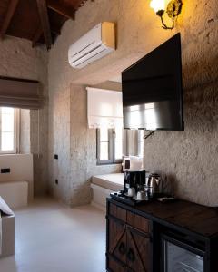 a room with a kitchen with a television on the wall at LA BİEN ALAÇATI by ALİİS in Çeşme