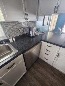 a kitchen with white cabinets and a black counter top at NEW Sunset Cottage - Lake Lida in Pelican Rapids
