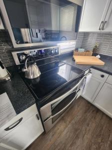 a kitchen with a stove with a tea kettle on it at NEW Sunset Cottage - Lake Lida in Pelican Rapids +21 photos