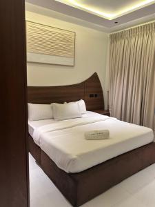 a bedroom with a large bed with white sheets at Greyfield Apartment Anex in Benin City +18 photos