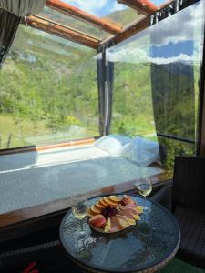 a plate of food on a table with two glasses of wine at Mountain Paradise in Merisi 2 in Merisi