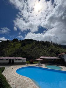 a swimming pool with a mountain in the background at Playita Salomon in Baños