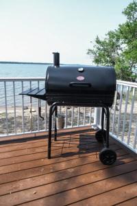 a grill sitting on a deck next to the beach at Amazing Grace Etta Shores in Henning +43 photos