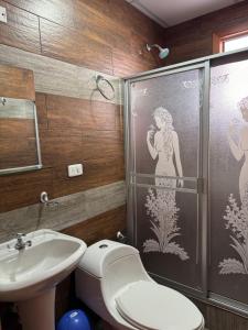 a bathroom with a shower and a toilet and a sink at Playita Salomon in Baños +14 photos