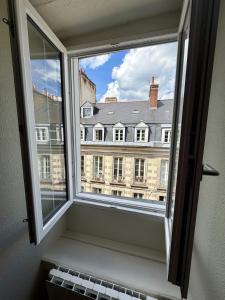 a window with a view of a large building at Le B - Appartement centre ville en duplex in Rennes +5 photos