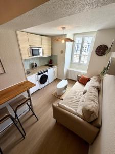 a living room with a couch and a kitchen at Le B - Appartement centre ville en duplex in Rennes
