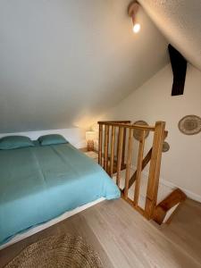 a bedroom with a bed and a wooden staircase at Le B - Appartement centre ville en duplex in Rennes