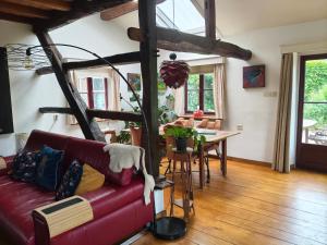 a living room with a red couch and a table at 't Wirkes in Schimmert