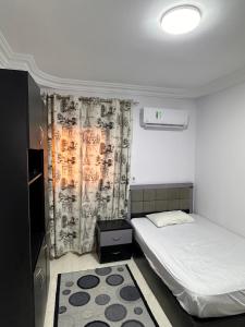 a small room with two beds and a curtain at Spacious Apartment In 6 October in 6th Of October